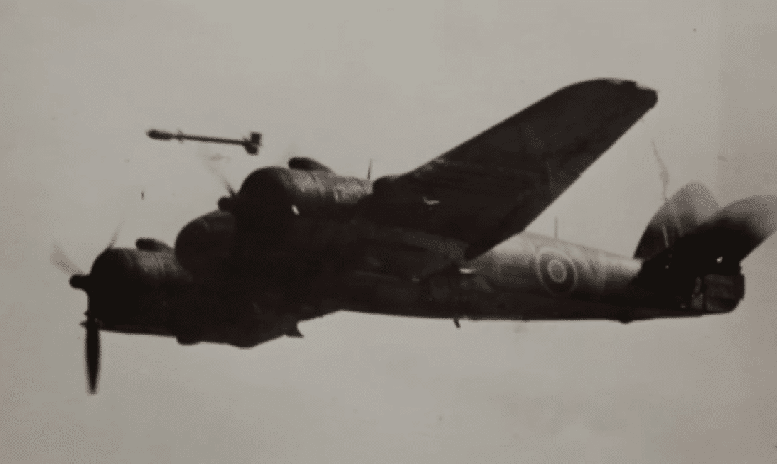 A Bristol Beaufighter caught in silhouette, releasing a rocket from its wing while flying.