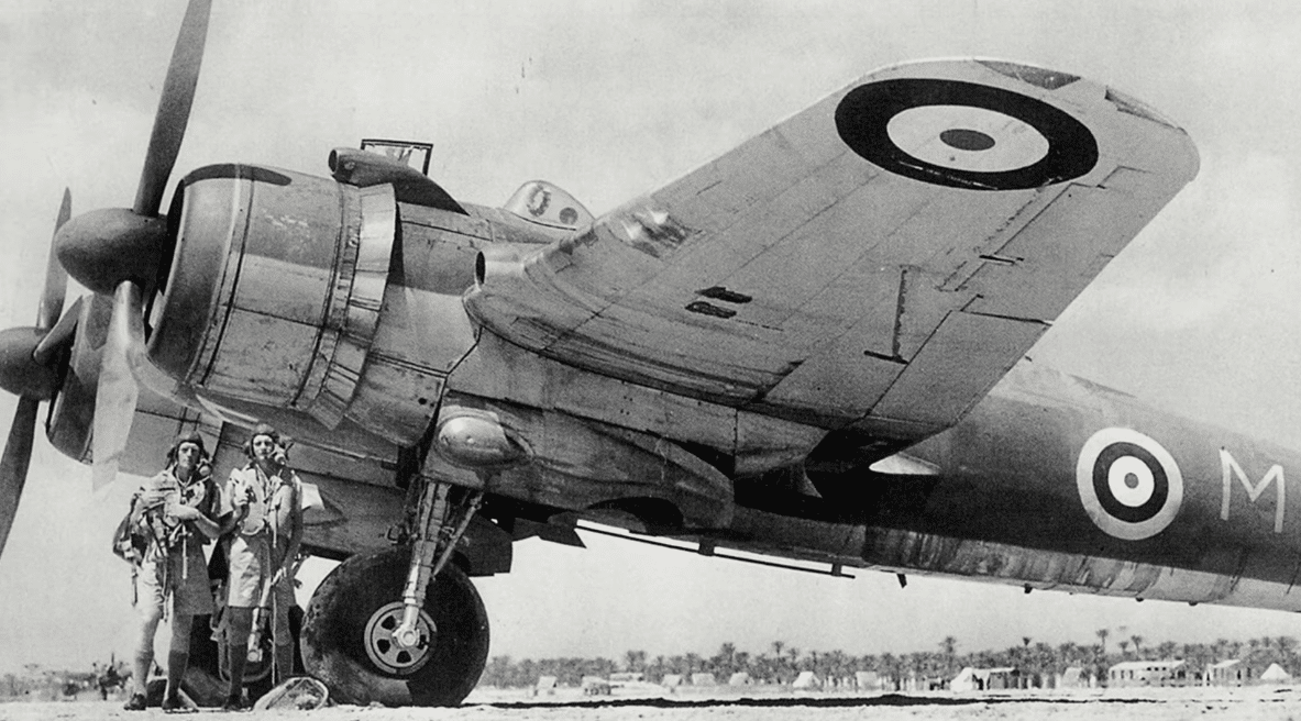 A Bristol Beaufighter parked on an airfield, with two uniformed crew members standing beside its wing.